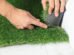Man cutting artificial grass carpet indoors, closeup