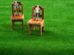 Men figures on wooden toy chairs on artificial grass
